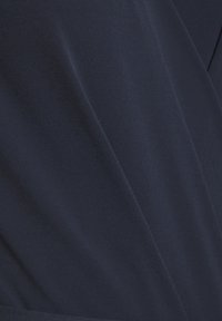 Tela azul marino con una textura suave y un diseño drapeado, que muestra pliegues sutiles y un color sólido sin patrones ni adornos.