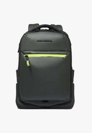 Sac à dos vert foncé en matériau durable, doté d'une poche avant zippée avec une fermeture éclair vert néon, de bretelles rembourrées et d'un design structuré.