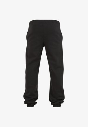 Juodos laisvalaikio kelnės su elastine liemene ir elastinėmis kelnėse apačiomis, parodytos iš nugaros ant balto fono.