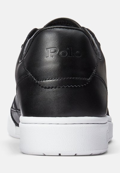 Črne usnjene superge z belo gumijasto podplatom. Ponuja šivane detajle in vtisnjen logotip "Polo" na zadnjem delu. Gladka tekstura.