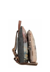 Zwei Taschen nebeneinander: Eine zeigt ein graues, strukturiertes Design, die andere ist hellbraun mit einem Blumenmuster und einem dekorativen Anhänger.