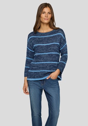 Gestreifter Pullover in Blau und Hellblau mit weitem Ausschnitt und Dreiviertelärmeln, kombiniert mit blauen Jeans. Weiche Textur und entspannter Schnitt.