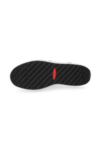 Suela de zapato de goma negra con una superficie texturizada y con patrón, y un acento rojo en el logo. Presenta surcos profundos para mayor tracción.