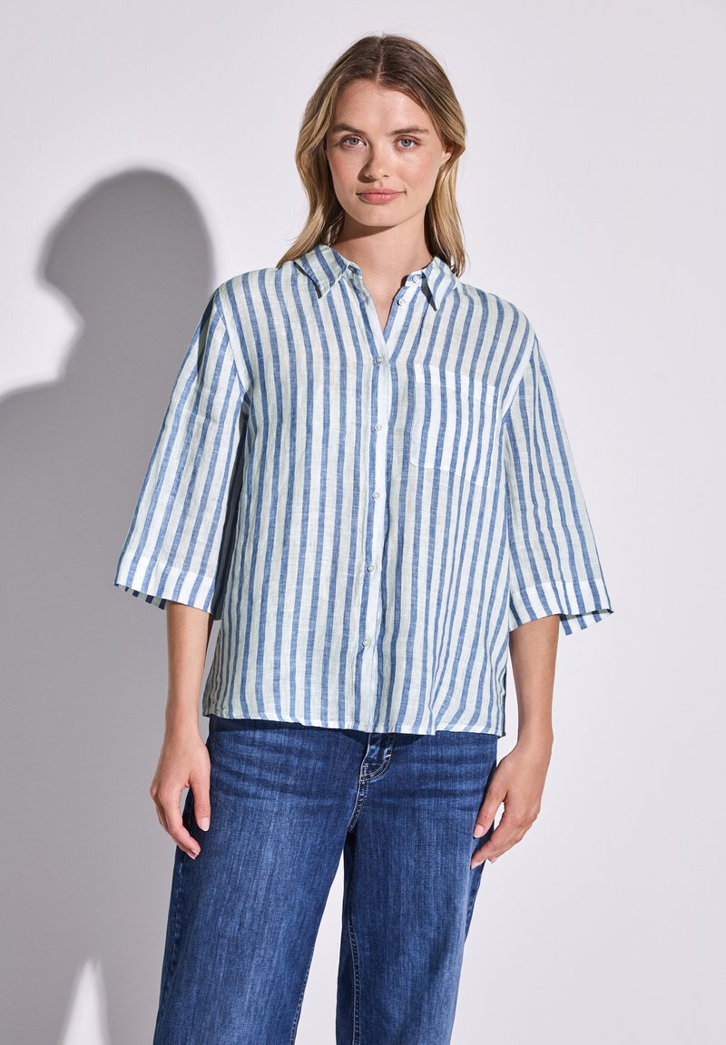 Camicia a maniche corte, con bottoni, in blu chiaro e righe bianche, realizzata in lino, con taschino sul lato sinistro e vestibilità comoda.