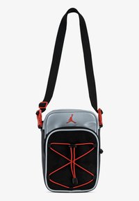 Borsa a tracolla nera e silver con accenti rossi, caratterizzata da un design con corda elastica frontale e tracolla regolabile. Realizzata in materiali sintetici.