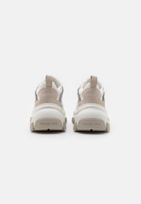 Vita och beige sneakers med mocka- och nätaccentuering, rundad tå, kraftig sula och prägling av logotyp på hälen och baksidan.