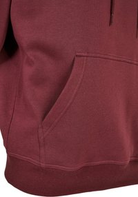 Bordeaux sweatshirt med kængurulomme, ribbede manchetter og kant. Blød tekstur med en glat finish. Designet inkluderer subtile syning detaljer.