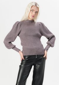 Purple ribbed-knit sweater with high neck and puffed sleeves, paired with black leather pants, showcasing textured fabric and fitted design.