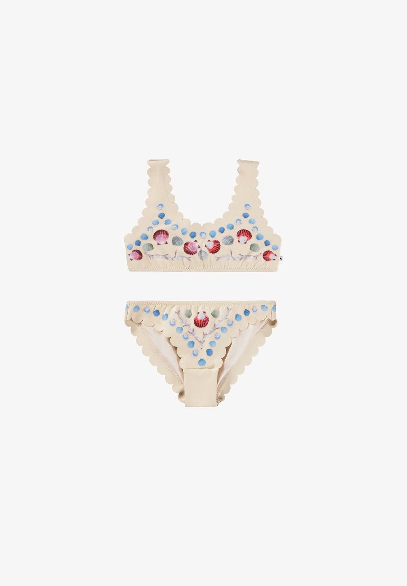 Δίχρωμο μαγιό, μπεζ με κυματιστές άκρες, που διαθέτει πολύχρωμα σχέδια από κοχύλια και κουκίδες. Μαλακό ύφασμα με μέτρια ελαστικότητα.