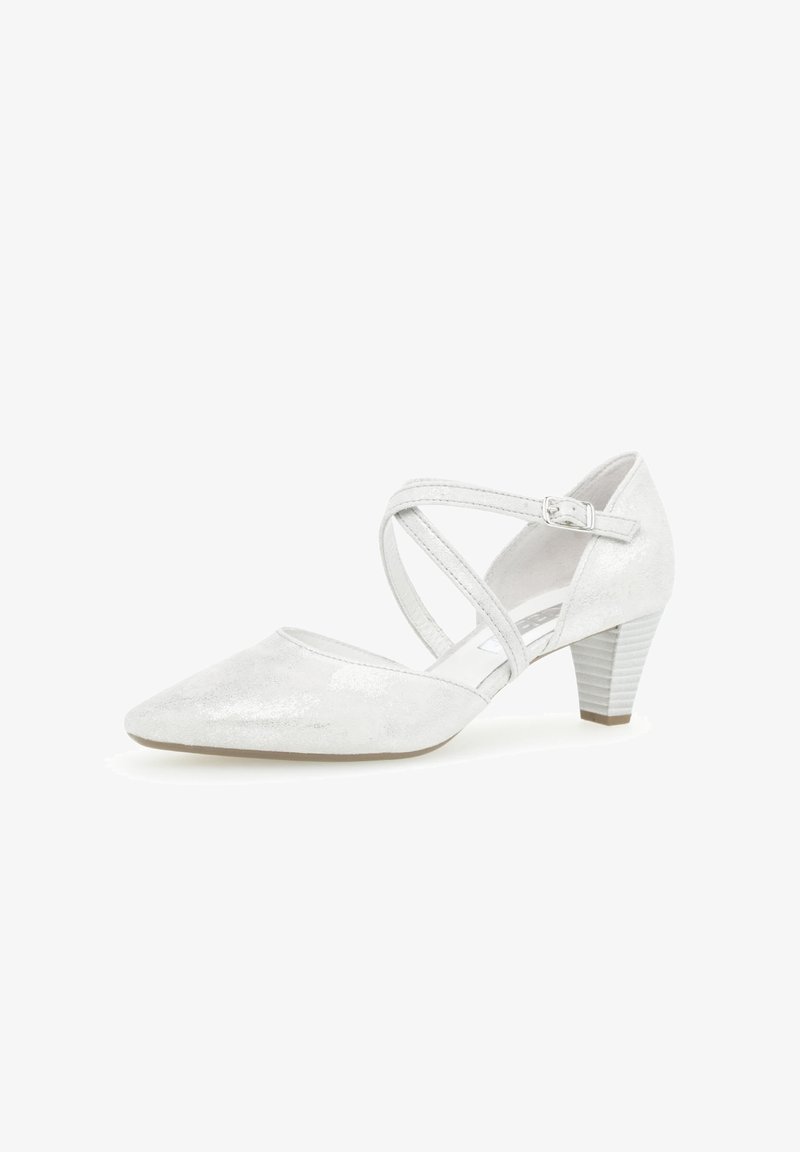 Chaussure femme à talon bas en daim blanc avec un bout pointu et des brides croisées à la cheville fixées par une petite boucle en argent.