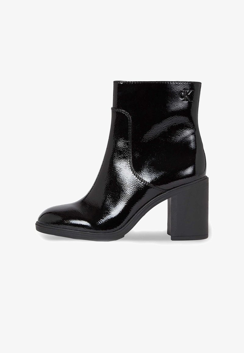 Sort patenteret læder ankelstøvle med firkantet tå og kraftig hæl. Har en sideslids og et diskret logo på anklen.