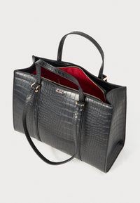 Black crocodile-embossed tote bag with gold hardware, dual handles, and a red interior. Features a zipper closure and structured shape.