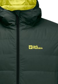 Doudoune vert foncé avec un intérieur jaune vif et un logo, dotée d'un grand col et d'une fermeture éclair frontale sur toute la longueur. Texture lisse.