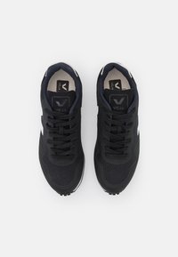 Baskets en mesh noir avec dessus texturé, bout rond et détails blancs. Dotées de lacets plats et d'un logo contrastant sur la languette.