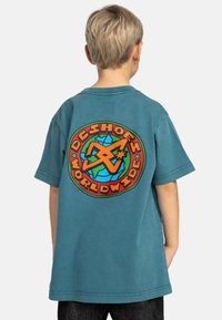 Teal bomull t-shirt med korta ärmar, prydd med en färgglad grafisk logotyp på baksidan som visar en glob och texten "DC Shoes Worldwide."