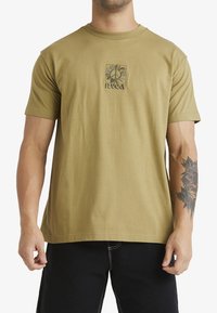 Camiseta de algodón verde oliva con un diseño gráfico centrado que presenta motivos florales y de paz. Mangas cortas y escote redondo.