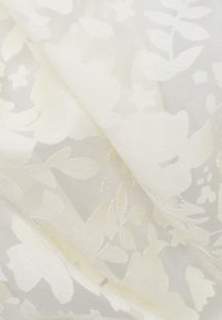 White floral lace fabric featuring a delicate, textured pattern with soft, sheer sections and subtle sheen.