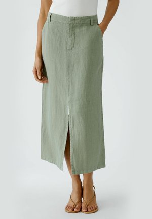 Light green linen skirt with a straight design, front slit, and belt loops. Features side pockets and a textured finish.
