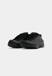 Pantofi sport negri cu un design superior perforat, material texturat și o talpă conturată. Șireturile sunt de asemenea negre, asigurând un aspect uniform.