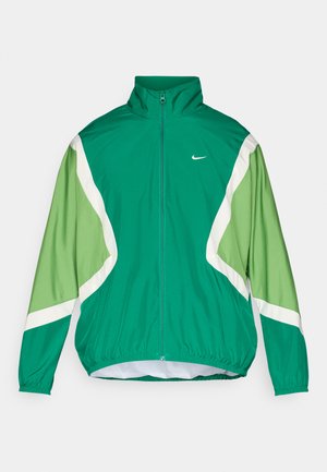 Grøn og lysegrøn zip-up jakke med høj krave, elastiske manchetter og kant. Har hvide accenter og et lille Nike logo på brystet.