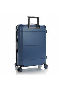 Hard-shell carry-on suitcase in navy blue with a textured finish, telescopic handle, and four smooth-rolling wheels for easy mobility.