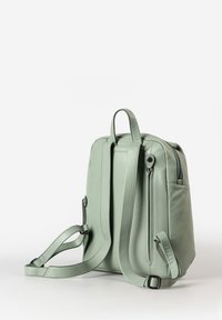 Hellgrüner Leder-Rucksack mit zwei verstellbaren Trageriemen, oberen Handgriffen und einer Seitentasche; glatte Oberfläche mit einem Reißverschluss.