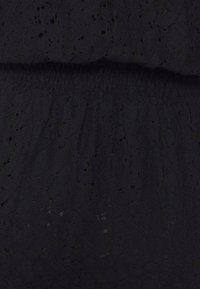 Czarna tkanina sukienkowa z florystycznym wzorem koronkowym, z fakturowaną powierzchnią i elastycznym pasem w talii dla dopasowanego fasonu.