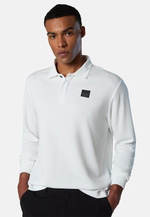 White long-sleeve polo shirt with a soft texture, featuring a buttoned collar and a square black logo patch on the left chest.