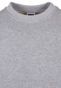 Sudadera gris claro con un cuello redondo acanalado. El material tiene una textura suave y lisa con un sutil patrón jaspeado. Etiqueta visible dentro del cuello.