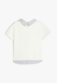 Blusa blanca de manga corta con cuello y dobladillo a rayas, presenta un detalle en la parte trasera en forma de ojo de cerradura y una textura suave de algodón.