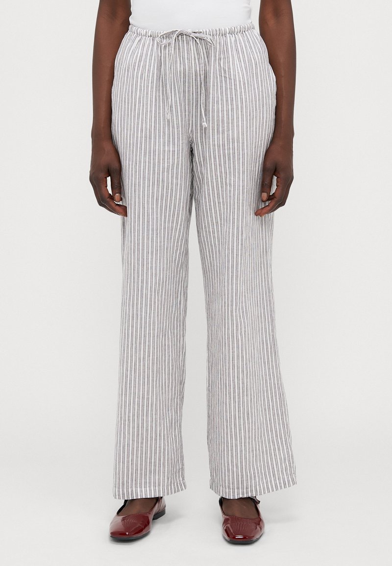 Pantaloni in misto lino a righe con vita elastica, cordoncino e gamba larga. Presentano righe grigie chiare e bianche con una leggera trama.