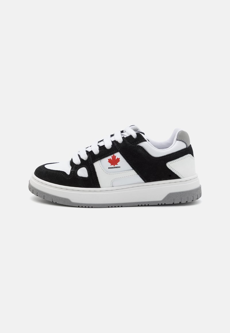 Black suede and white leather sneakers feature a red maple leaf logo, thick white laces, and a grey rubber sole with textured tread.