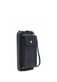 Compact zwart lederen polsportemonnee met ritssluiting en voorklep met drukknoop, staand rechtop weergegeven op een witte achtergrond.