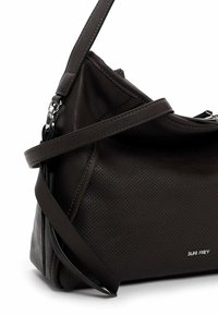 Sac en cuir marron foncé à bandoulière avec texture perforée, sangle ajustable et quincaillerie argentée avec logo de la marque.