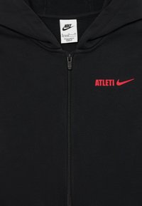 Czarna bluza z zamkiem, wykonana z miękkiego materiału, z czerwonym napisem "ATLETI" oraz czerwonym logo Nike na przodzie.