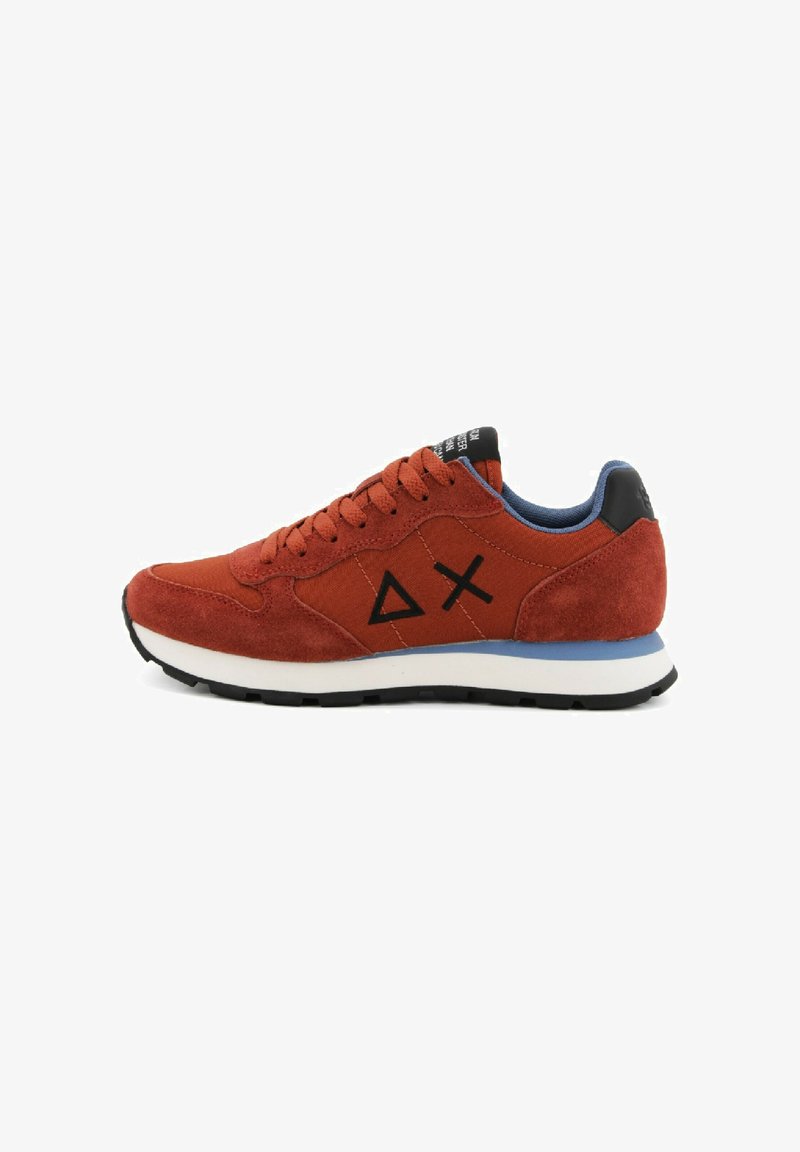 Rode suède sneaker met zwarte accenten, witte tussenzool, blauwe voering en een driehoekig logo. Heeft ronde veters en textuurlagen.