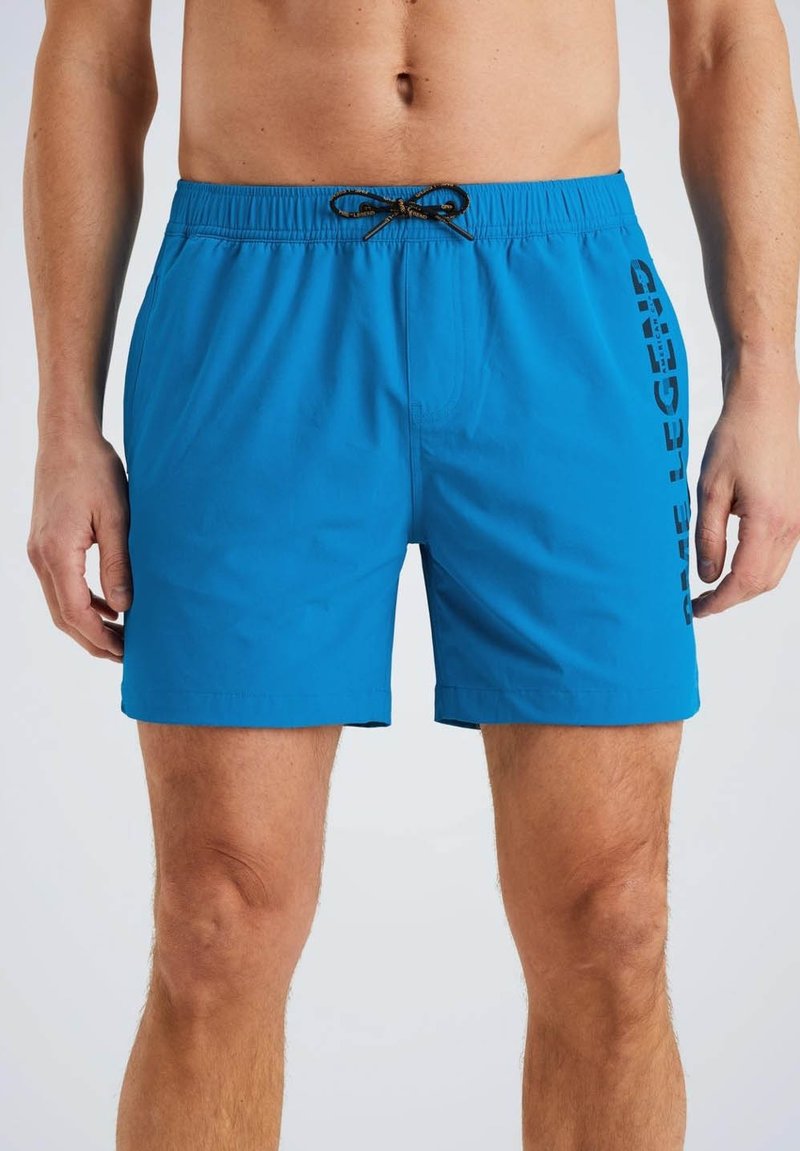 Shorts de bain bleus avec une taille élastique, un cordon de serrage ajustable et un texte imprimé sur le côté. Fabriqués en matériau léger et à séchage rapide.
