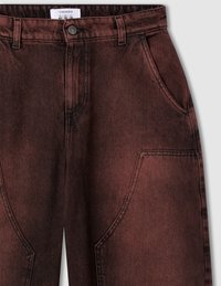 Pantaloni in denim color ruggine con vita alta, design a cinque tasche e dettagli di cucitura prominenti. Chiusura classica con bottone e cerniera.