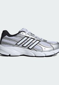 Strieborná športová obuv s sieťovaným zvrškom, čiernymi akcentmi, bielymi pruhmi a polstrovanou podrážkou označenou "CLOUDFOAM" pre pohodlie a oporu.