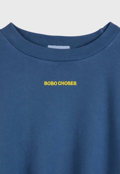 Blå sweatshirt med ribbad rundhals och broderad "BOBO CHOSES"-logotyp i gult. Slät textur och enkel design utan mönster.
