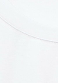 Tela de algodón blanca con una textura suave, presenta un cuello redondo y costuras visibles a lo largo del cuello.