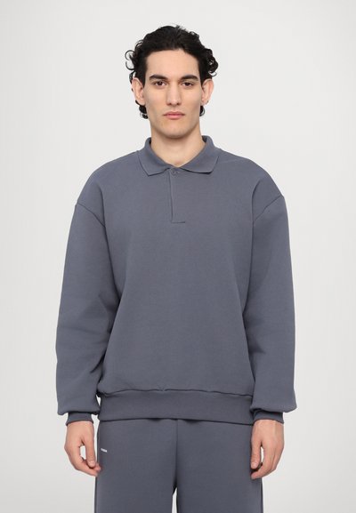 Šedý svetr s rolákem, dlouhými rukávy a žebrovaným lemem. Měkká textura, uvolněný střih a jemné detaily.