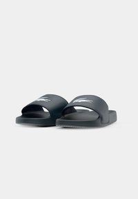 Dark blue slide sandals with a soft rubber upper, wide band, and textured footbed. Features a white logo on the top strap.