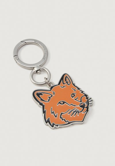 Silver keyring with orange enamel fox head charm outlined in black, attached to a round clasp engraved with "MAISON KITSUNÉ."