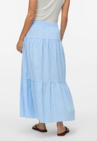 Blå och vit rutig maxi kjol med lager på lager och elastisk midja. Materialet verkar lätt och strukturerat.