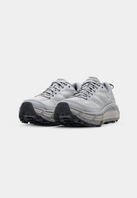 Hellgraue Wanderschuhe mit einem Obermaterial aus Mesh, verstärkter Zehenpartie, robuster Gummisohle und dämpfender Zwischensohle. Verfügt über Rillen für besseren Halt.