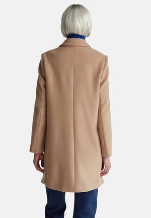 Abrigo de lana beige con un corte entallado, mangas largas y cuello con muescas. Textura suave y silueta recta, que destaca un diseño minimalista.