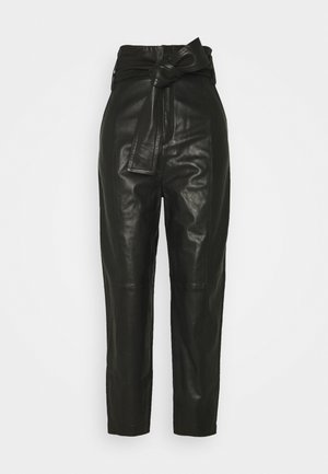 Zwarte leren broek met hoge taille en een gestrikte riem in de taille, met taps toelopende pijpen.