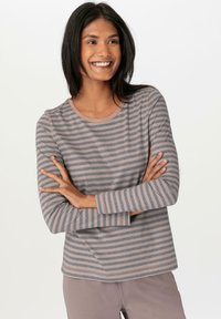 Gray and beige striped long-sleeve shirt with a round neckline, soft texture, and relaxed fit, styled with light-colored pants.