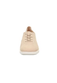 Beige lässiger Schnürschuh mit weißer Sohle, von vorne auf einem weißen Hintergrund betrachtet.